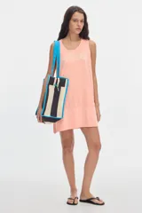 Cartera tote bag con diseño de rayas verticales en negro y blanco, asas de hombro y ribetes en color celeste. Cuenta con cierre superior y estampa con el nombre de la marca.