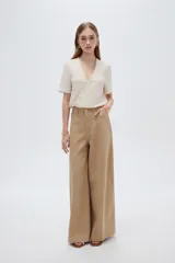 Pantalón jean verde militar, de tiro alto, corte ancho tipo wide leg y diseño de perneras amplias con costuras verticales decorativas.