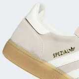 Championes Adidas Handball Spezial de ante vacuno en color beige, con las clásicas tres tiras laterales en blanco, suela de goma color caramelo y detalles dorados con el nombre del modelo en el lateral.