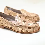 Mocasines de cuero con acabado de pelo, estampado animal print con acabado metalizado dorado, taco bajo y punta redondeada.