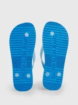 Ojotas de playa con suela y tiras en degradado de azul claro a celeste, con el logo de Calvin Klein Jeans estampado en blanco en la plantilla y en la tira.