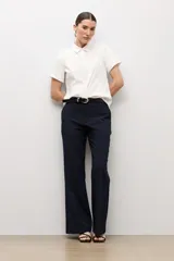 Camisa clásica blanca de manga corta, con cuello camisero y cierre frontal oculto con botones.