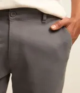 Pantalón de sarga para hombre, de corte recto y diseño básico. Cuenta con cintura fija con trabillas para cinturón, cierre frontal con cremallera y botón, y bolsillos laterales y traseros.