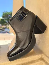 Botinetas de cuero en combinación tricolor de marrón, tostado y beige, con plataforma y taco ancho de madera. Cuenta con detalle de tira con hebilla en el lateral y cierre interno.