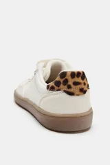 Zapatillas deportivas barefoot de color blanco con detalles en beige y suela de goma marrón. Presentan cordones blancos y detalle de estampado animal print de leopardo en la talonera.