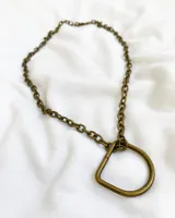 Collar de cadena de eslabones color bronce con dije circular.