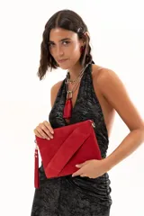 Vestido largo de fiesta con escote halter profundo y espalda descubierta. Presenta un diseño drapeado en la zona central del torso y una falda fluida con tajo lateral. Confeccionado en tejido con acabado brillante tipo lurex.