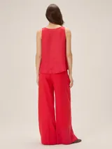 Pantalón sastrero de corte ancho, color beige con rayas verticales blancas y detalles de costuras pespunteadas.