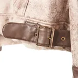 Campera estilo aviador con exterior de efecto gamuzado en tono beige y detalles en cuero sintético marrón. Cuenta con interior y solapas de piel sintética en color crema, cierre frontal cruzado y bolsillos laterales.