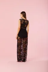 Vestido largo de encaje guipure negro, con escote en V, diseño sin mangas y corte recto. Presenta una textura calada con motivos florales y una silueta elegante.