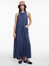 Vestido largo sin mangas color azul marino, confeccionado en lino, con cuello camisero y espalda descubierta con ajuste regulable. Presenta un escote halter y bordado tipo pespunte en contraste sobre el cuello.