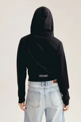 Campera crop tipo hoodie color negro, con capucha, cierre frontal metálico y bolsillos canguro. Presenta diseño corto y bordado sutil de la marca en el pecho.