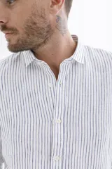 Camisa celeste a rayas verticales blancas, de manga larga y corte clásico.
