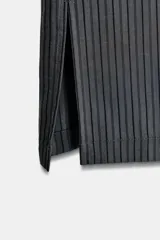 Pantalón de tiro medio con diseño de pierna ancha y estampado de rayas verticales. Cuenta con cintura elástica ajustable mediante cordones y bolsillos laterales ocultos en la costura, con aberturas en el bajo.