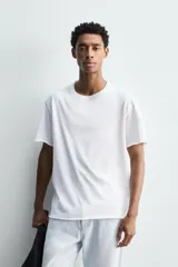 Camiseta de corte relajado confeccionada en algodón ligero, con cuello redondo y mangas cortas con bordes de acabado irregular.
