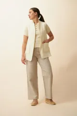 Chaleco color crema con solapas, corte entallado y bolsillos plaqué.