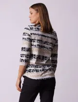 Remera de algodón con estampado floral y de rayas horizontales en tonos azules, negros y beige. Presenta escote redondo a la base y mangas tres cuartos.