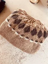 Sweater tejido a mano con patrón de hojas en tonos marrón, beige y blanco.