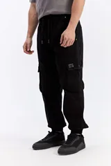 Pantalón cargo color tostado de corte amplio, con cintura elástica y cordón ajustable. Cuenta con bolsillos laterales con tapa en las piernas y puños elastizados en los tobillos.