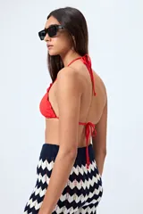 Top de bikini negro con tirantes finos y volados en el borde.