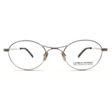 Armazón de lentes Linea Roma con diseño ovalado, fabricado con baño de oro de 18 quilates. Presenta una estructura metálica delgada y elegante con patillas texturizadas.