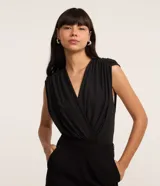 Body femenino de la marca Blue Steel, confeccionado en tejido de poliéster con elastano. Presenta un diseño sin mangas con escote en V cruzado y detalle de hombreras, ofreciendo un ajuste cómodo y elegante.