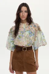 Blusa de algodón y seda con diseño estampado floreado, cuello mao, mangas anchas y detalles de mini volados y bordados en el pecho.