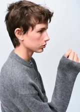 Chaqueta de punto grueso color gris, con cuello redondo, diseño recto, manga larga y cierre delantero con botones.