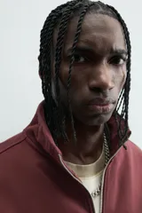 Sudadera roja de corte regular, con cuello alto y cierre frontal de cremallera. Manga larga y terminaciones en rib.