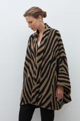Ruana de punto jacquard con estampado animal print de cebra en colores negro y tostado, de diseño abierto y corte holgado.
