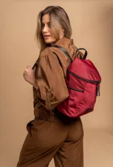 Mochila urbana de diseño compacto en color negro, confeccionada en nylon resistente. Cuenta con un compartimento principal con cierre, bolsillo frontal con cierre y correas ajustables con detalle de marca.