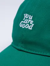 Gorro marrón de gabardina con visera y bordado frontal con la frase "You are Good" en color blanco.