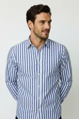 Camisa de algodón a rayas verticales azules y blancas, de manga larga, con cuello camisero y cierre frontal con botones.