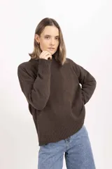 Buzo de punto color marrón chocolate, con cuello redondo y puños y ruedo acanalados. Diseño minimalista de calce holgado.