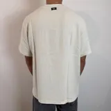 Remera de lino color beige, de corte regular, con cuello redondo y mangas cortas.