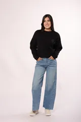 Pantalón de jean estilo wide leg con tiro alto, diseño de costuras diagonales en el frente y ruedo deshilachado.