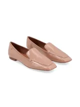 Mocasines de cuero texturado con trama símil reptil en color crema, con punta cuadrada, tacón bajo y detalle de aplique metálico dorado con logo en el lateral.