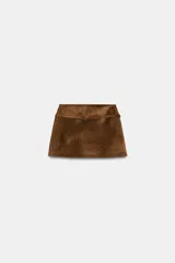 Falda pantalón de tiro medio confeccionada en tejido con efecto ante, con cinturón fino integrado del mismo material y hebilla metálica, y cierre lateral con cremallera oculta.