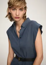 Vestido midi de diseño recto con cuello camisero y cierre frontal de botones. Presenta mangas cortas y aberturas laterales en el bajo. Incluye un cinturón ajustable con hebilla metálica.