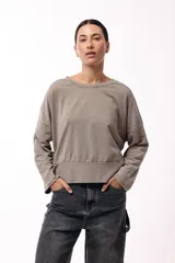 Remera de silueta amplia con hombro caído y cuello redondo, confeccionada en tejido suave de algodón. Presenta un diseño holgado y versátil con mangas largas.