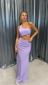 Vestido largo lila de un solo hombro con acabado brillante y diseño cut-out en la cintura.