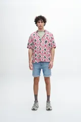 Camisa negra con estampado cachemir en blanco, de manga corta y corte recto.