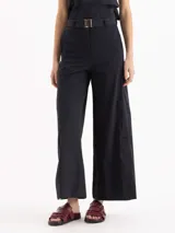 Pantalón wide leg negro de tiro medio-alto con elástico en la espalda, cinto con hebilla y tajos en las botamangas.