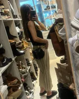 Bandolera negra de cuero gamuzado con solapa de cuero liso y cierre con tira de cuero.