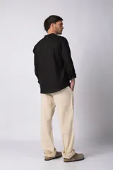 Camisa de manga larga confeccionada en lino, con cuello mao y cierre frontal de botones. Presenta un corte relajado y diseño minimalista.