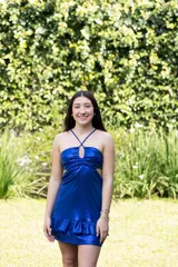 Vestido corto negro con escote en V, breteles finos cruzados en la espalda, abertura en la cintura y falda con volados.