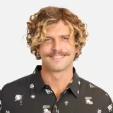 Camisa de manga corta negra con estampado de figuras geométricas en blanco. Tiene cuello clásico, cierre frontal con botones y un bolsillo en el pecho.