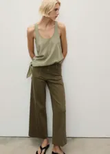 Pantalón de jean color verde oliva, de corte wide leg, tiro alto y largo al tobillo. Tiene bolsillos de parche delanteros y traseros, trabillas para cinturón y cierre frontal con cremallera y botón.