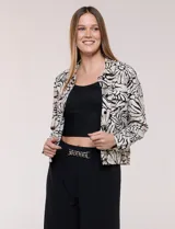 Camperita liviana de silueta entallada y largo a la cintura, con cuello camisero, cierre frontal de botones, mangas largas y bolsillos con solapa en el pecho. Presenta estampado animal print.