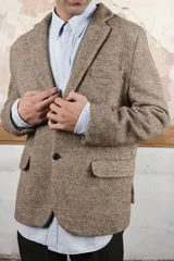 Saco sport marrón claro con medio forro, botones y coderas de cuero. Corte holgado, ideal para combinar con pantalón de vestir o jeans. Confeccionado en Uruguay con tela 100% lana fina sin teñir.